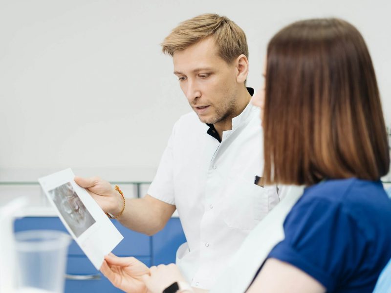 doctor-consulting-his-patient-discussing-tooth-treatment-plan-health-care.jpg