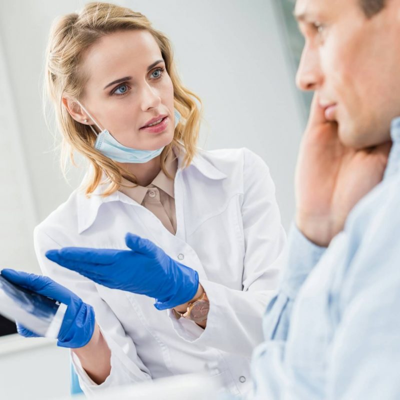 man-consulting-with-dentist-looking-at-x-ray-in-modern-clinic.jpg